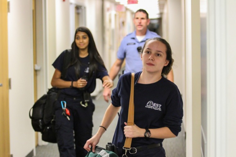 Emergency Support Team member Gaby Gonzalez and her colleague rush to an intoxication call in Liggett Hall to help stabilize the intoxicated student in September 2014. EST began over 30 years ago as the organization Students Helping Out (SHOut).