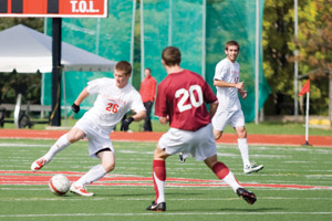 Bears midfielder Zach Hendrickson  works past a Carnegie Mellon defender. Hendrickson, a sophomore, had one shot on goal in the soccer team’s 2-0 loss to the Tartans. (Nora Jehle | Student Life