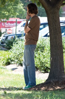 An unidentified student smokes a cigarette just outside of campus property.