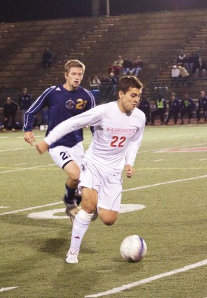 Sophomore Kenji Kobayashi runs the ball past Principia College forward Spencer Brown in their game Thursday night, scoring the first goal of the game.