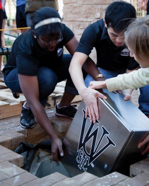 Students bury a time capsule containing a copy of Student Life, Dean McLeod’s hair, a CD, a menu and other artifacts.