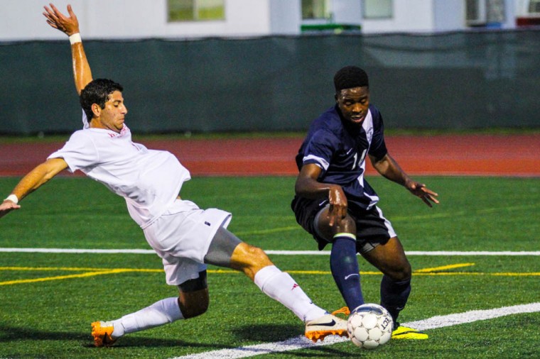 Freshman midfielder Shadi Awad makes a sliding tackle against a Westminister defender on Monday at Francis Field. 