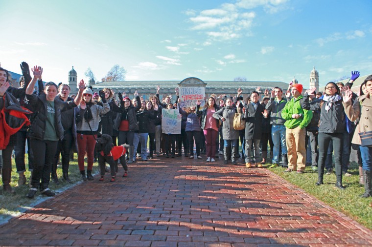 Students stand with their hands up in Brookings Quadrangle, adopting the “hands up, don’t shoot” pose that has become a symbol of solidarity with protesters in Ferguson, Mo.
