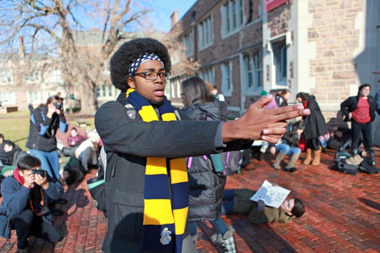 Senior Christian Gordon makes a symbolic gun with his hands, representing the shooting of Michael Brown in Ferguson, Mo., as part of an on-campus protest on Monday.