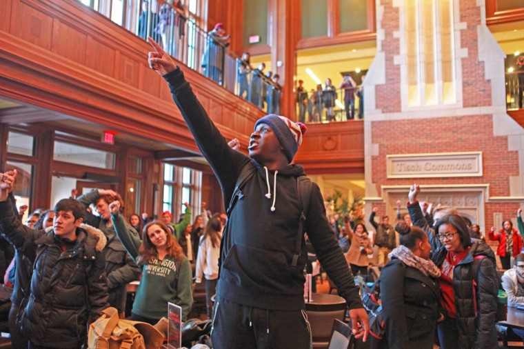 Protesters raise their fists in unison as part of a chanting session in the DUC.