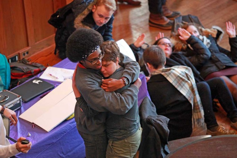 Two students hug during a die-in demonstration in the Danforth University Center, where Monday’s walkout event on campus culminated with a final call to action.
