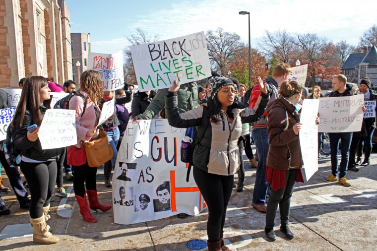 Students carry signs with messages about police brutality and racial discrimination.