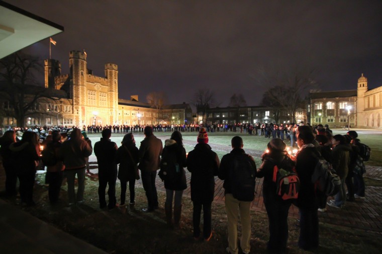 Students form a large circle in Brookings Quadrangle and hold candles in honor of the three Muslim students killed in Chapel Hill, N.C., on Tuesday. Around 200 students stood in complete silence for three minutes in honor of each of the three lives lost. 