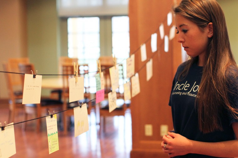 Senior Kelsey Stiles reads notecards in College Hall on Wednesday night. The PostSecret Reveal event was part of Mental Health Awareness Week, which is sponsored by Uncle Joe’s Peer Counseling, Active Minds and To Write Love on Her Arms.
