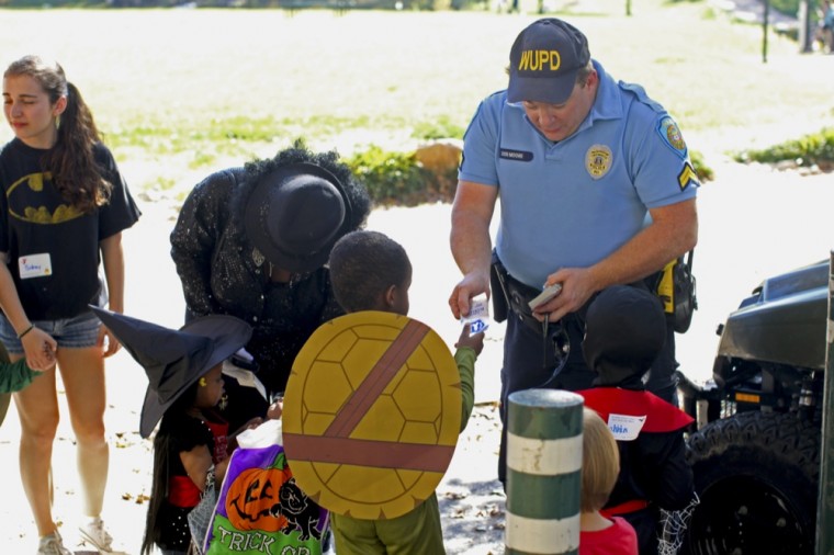 Don Moore, WUPD officer, hands out cards to children during last year's Safe Trick-or-Treat on the South 40.  The event, sponsored by the Campus Y, gives children an opportunity to celebrate Halloween in a safe environment.