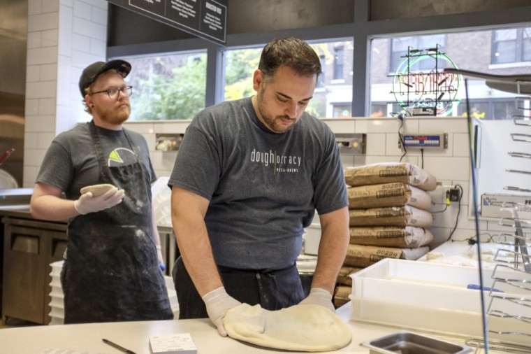 Workers shape pizza dough at Doughocracy. The Delmar location is the restuarant’s second in addition to a location in Geneva, Ill.