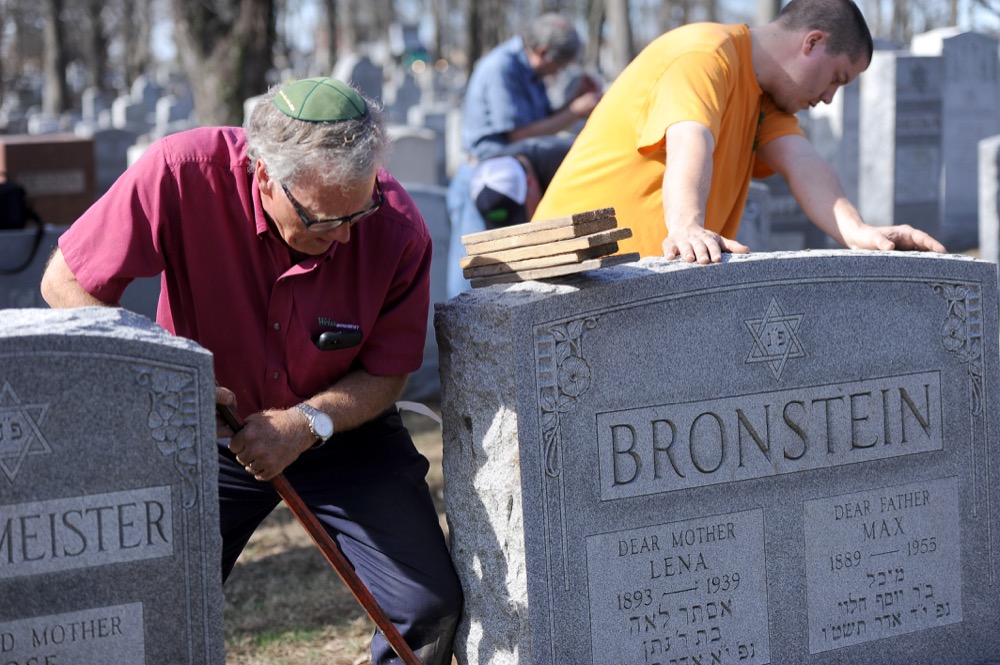 Community members work to repair headstones at Chesed Shel Emeth Cemetery after the cemetery was vandalized. Attendees reported that between 50-75 Washington University students attended the cleanup efforts, specifically an event held by Missouri governor Eric Greitens on Wednesday.