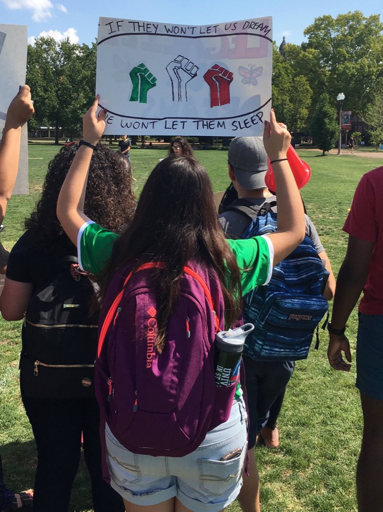 Students raise signs in protest of the Trump administration’s decision to roll back DACA as part of ALAS’ Hispanic Heritage month programming.