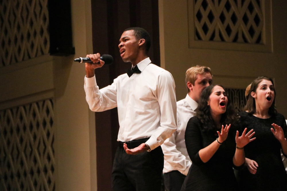 Co-ed a cappella group The Amateurs, founded in 1991, performs two songs onstage, closing out the a capella concert.