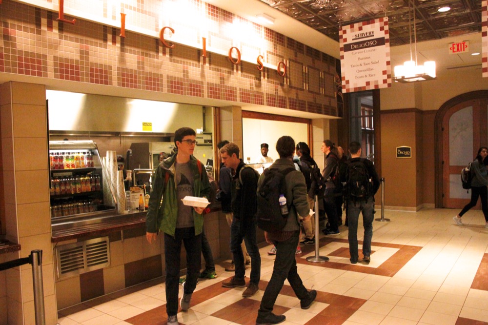 Students walk away from Delicioso, one of the dining options available for students in the Danforth University Center. Bon Appetit workers, who staff University dining stations, approved their first union contract Nov. 22.