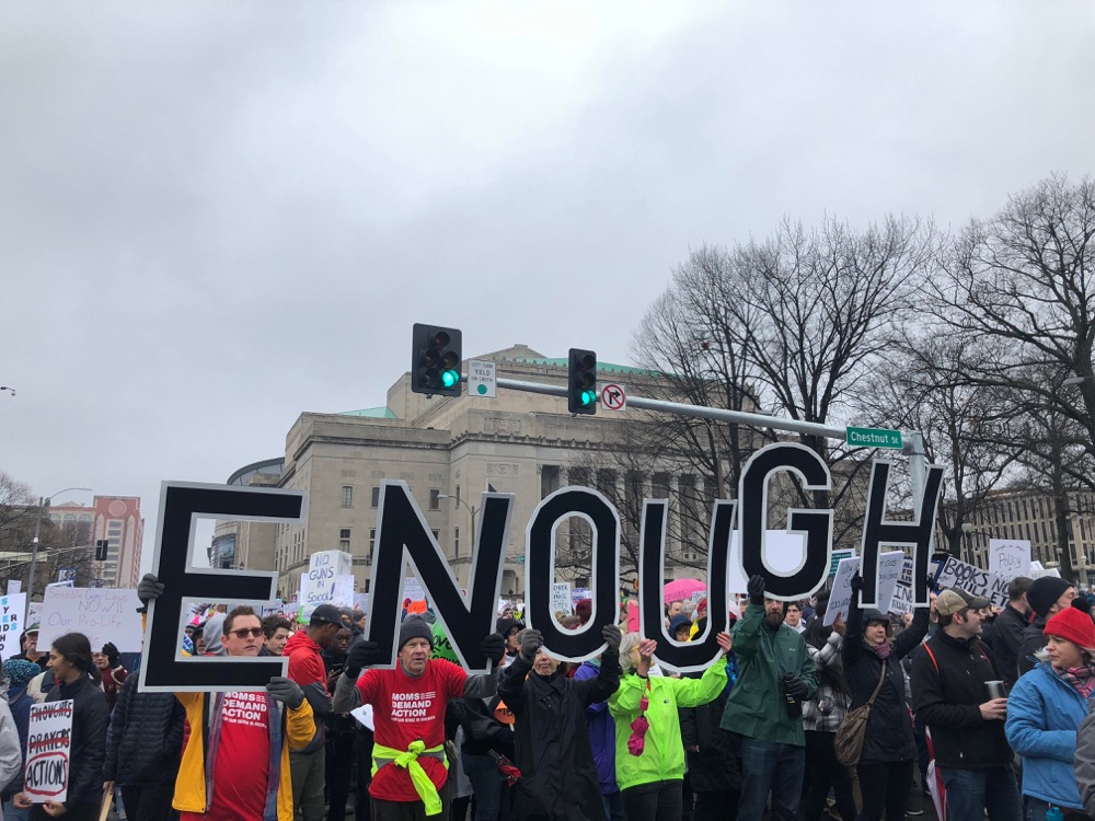 Protestors at the St. Louis March for Our Lives hold up signs spelling out “enough” Saturday, March 24. The March for Our Lives brought together students, teachers and activists from across the country in protest of gun violence in the wake of the Feb. 14 shooting at a Parkland, Fla. school.