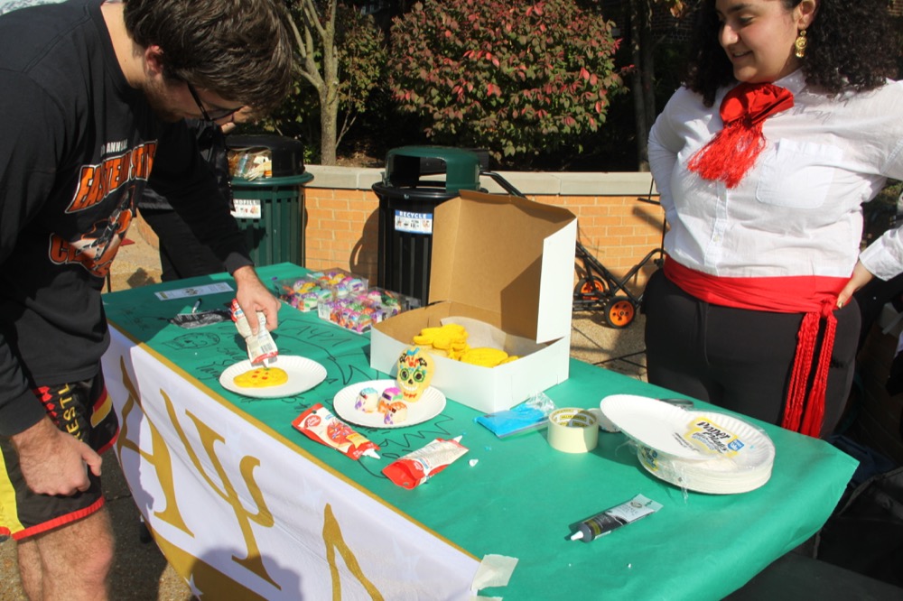 Sophomore Ted Flaherty decorates a sugar skull cookie at Alpha Psi Lambda’s table at El Mercado. Alpha Psi Lambda is Washington University’s only co-ed Latinx fraternity on campus.