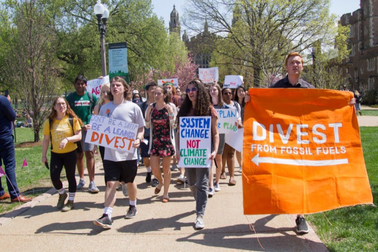 Fossil Free WashU members march around Mudd Field.