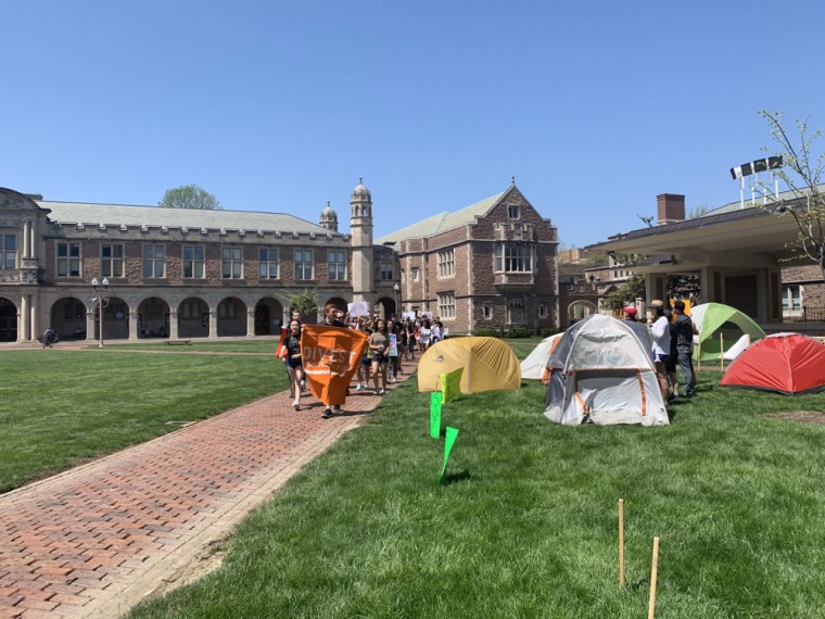 Fossil Free WashU marches past Washington University Graduate Workers Union members occupying Brookings Quadrangle. Participants plan to occupy Brookings until the University responds to their demands for $15 an hour.