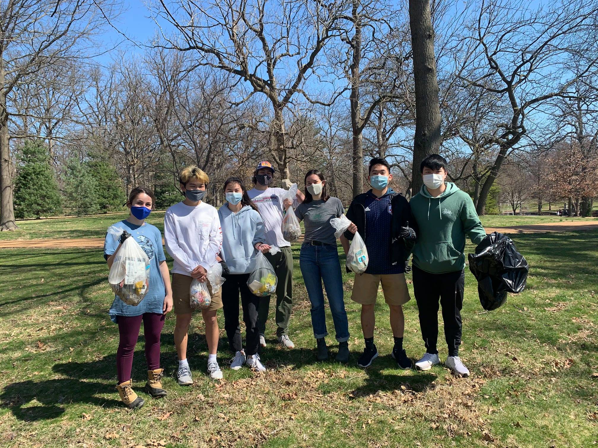 Photograph of students holding trash bags at a park.