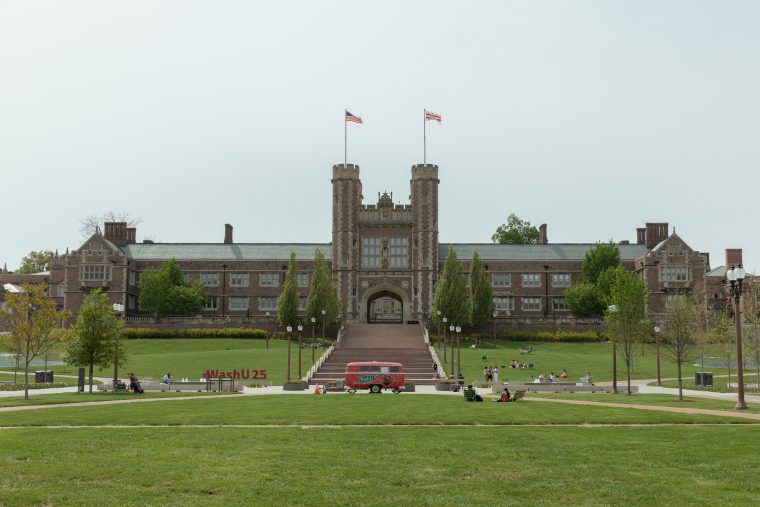 A large grassy lawn extends out in front of Brookings Hall.