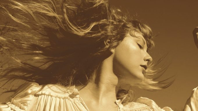 Part of the "Fearless (Taylor's Version)" album cover; Taylor Swift in sepia tones is turned to the right, hair flying behind her.