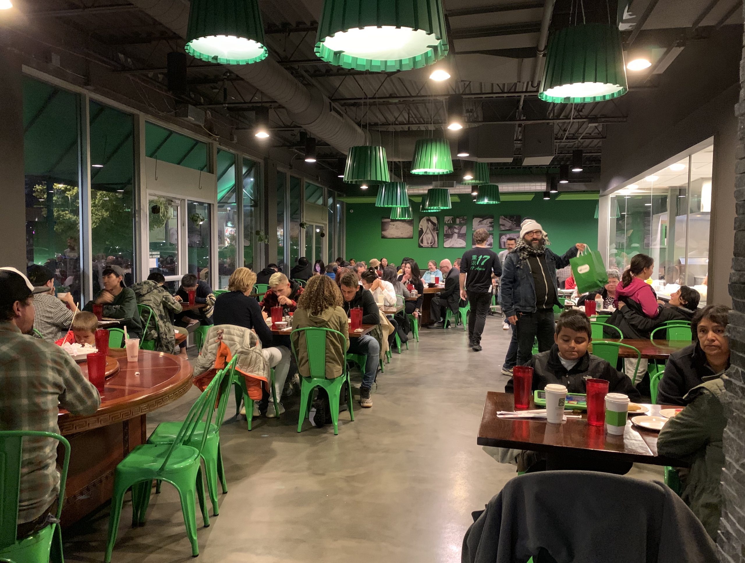 Many people are seated inside a crowded restaurant.