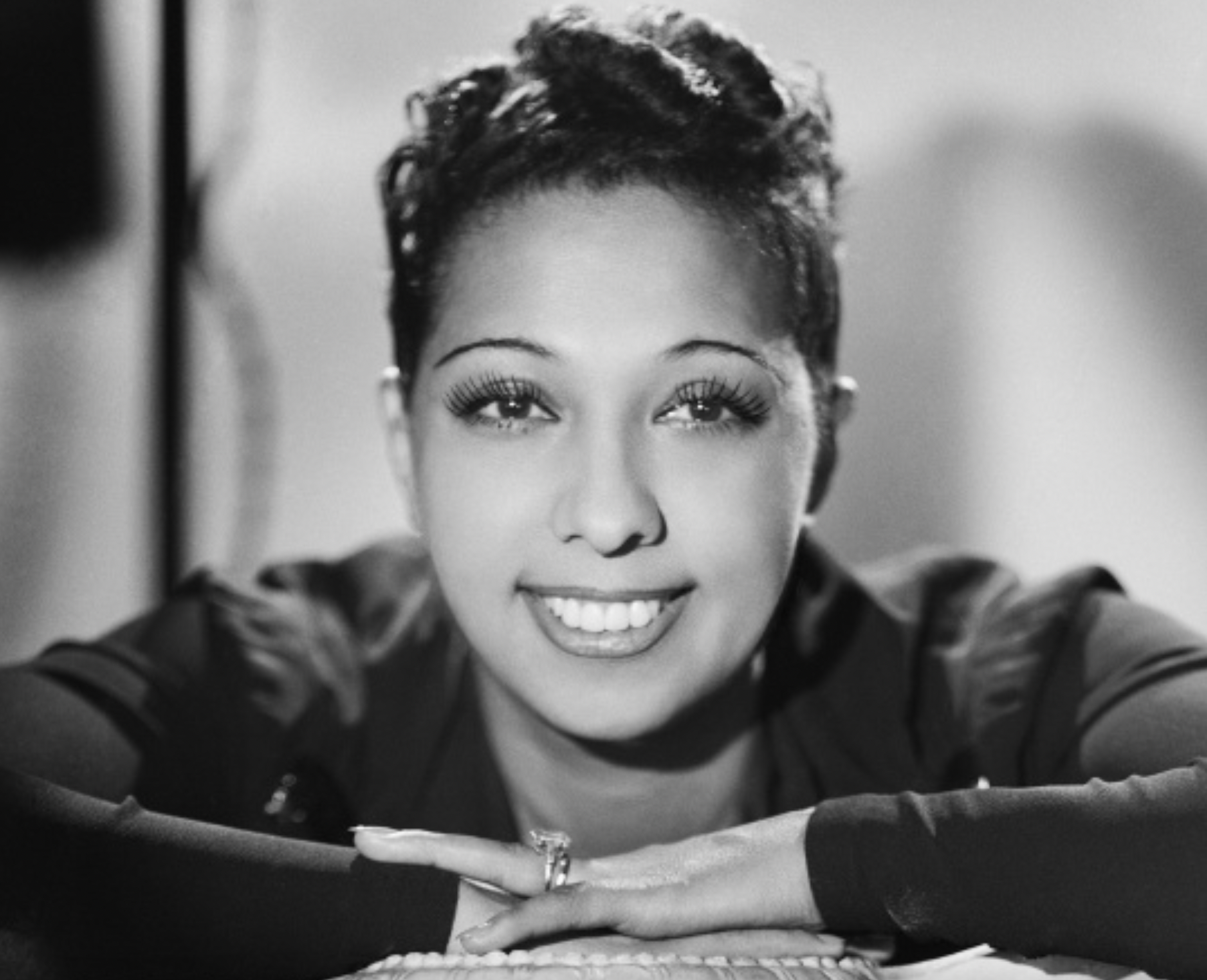A woman with short hair smiles directly at the camera.