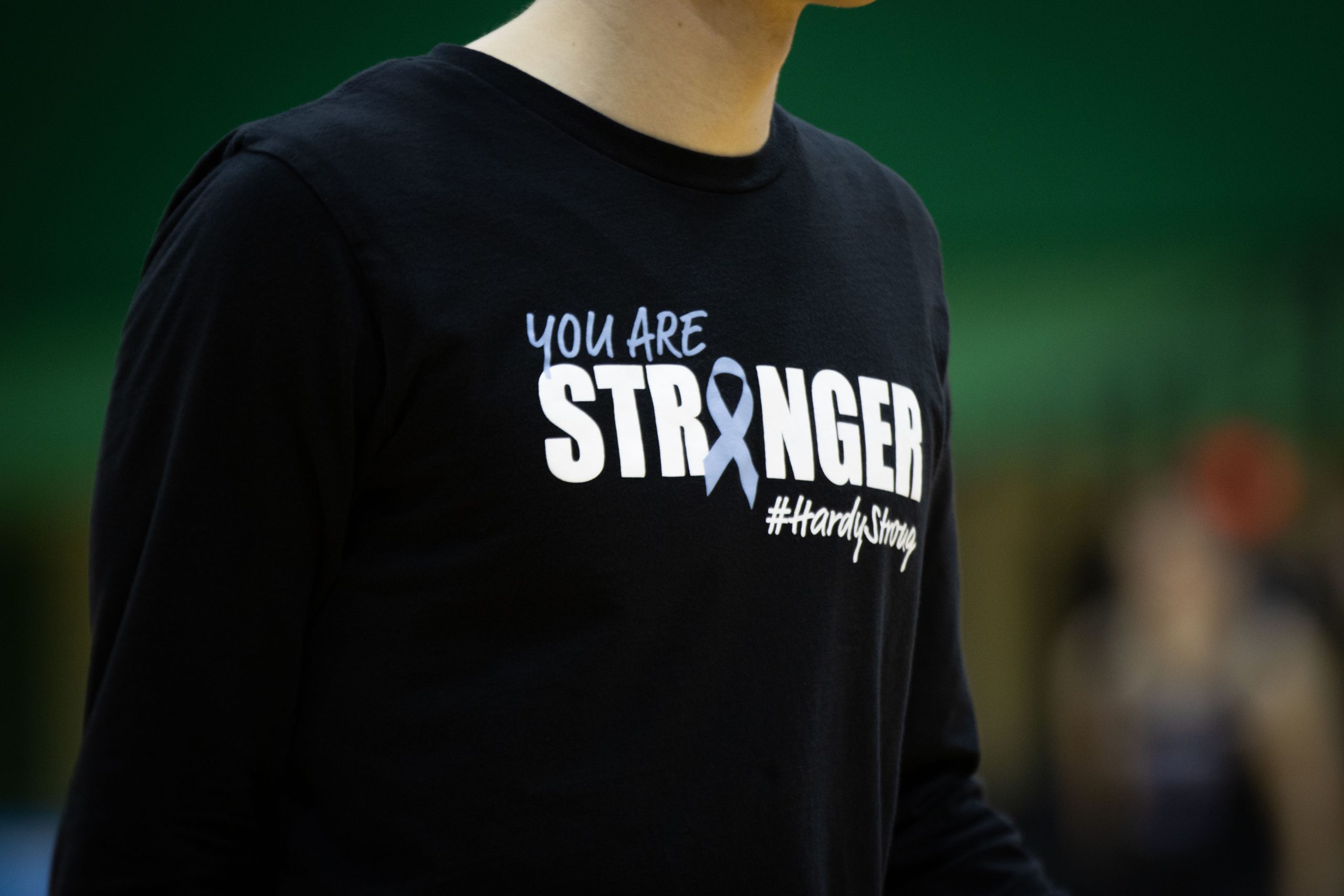 A black shirt worn by a player takes up most of the frame. In a white font, the shirt says You Are Stronger #HardyStrong